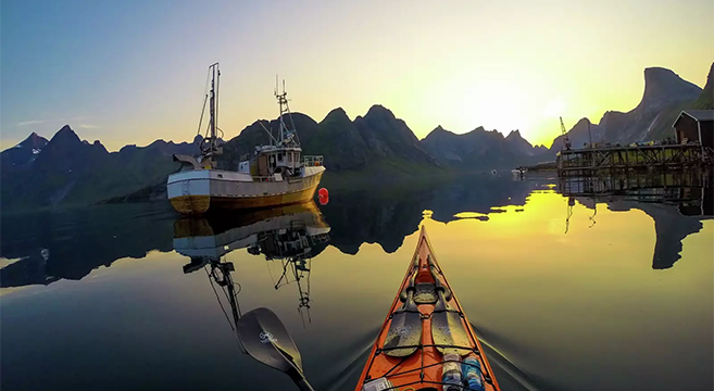 Kayaking at midnight in the fjords of Lofoten Norway
